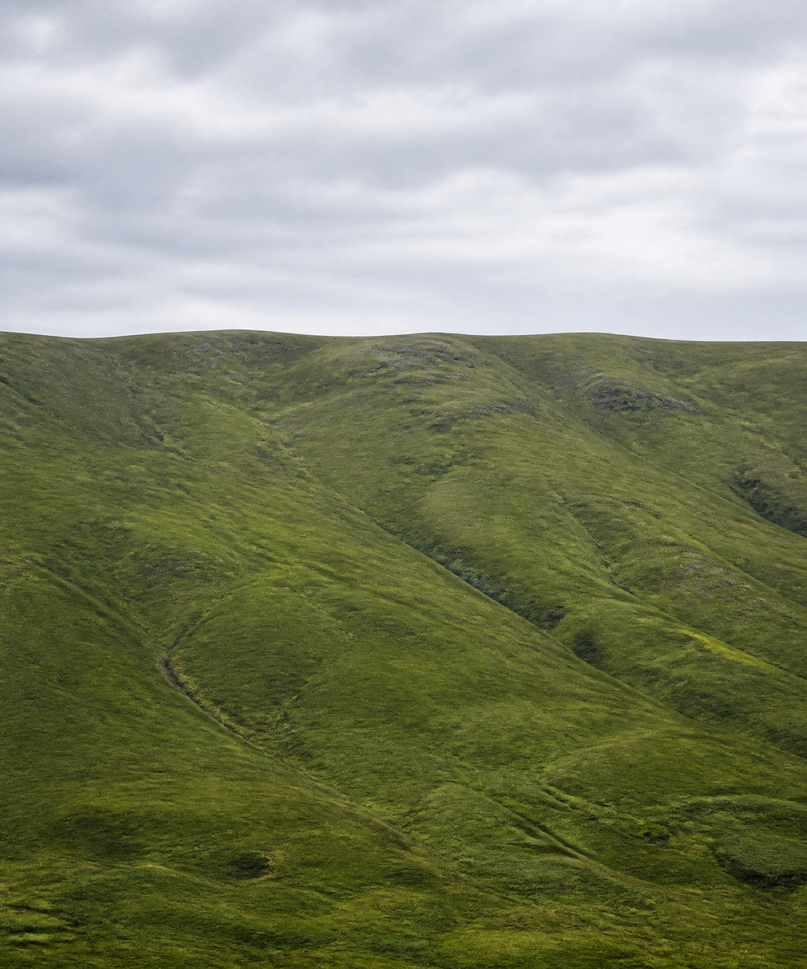 A distant green ridgeline beneath a wide open sky